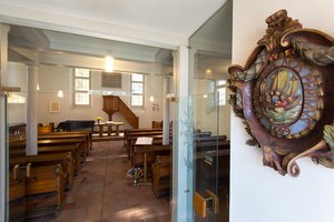 Der Innenraum der Französisch-reformierten Kirche in Offenbach ist schlicht gehalten. Das Gemeindewappen zeigt die Jünger auf dem See Genezareth im Sturm und trägt die Inschrift: "Herr, hilf uns, wir gehen unter. 1699" | Foto: Rolf Oeser