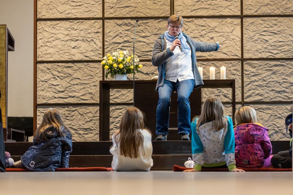 Auf den Stufen des Altarraums der Sankt Jakobskirche lauschten Kinder der Bibelerzählerin Veronika Bürker. I Foto: Rolf Oeser