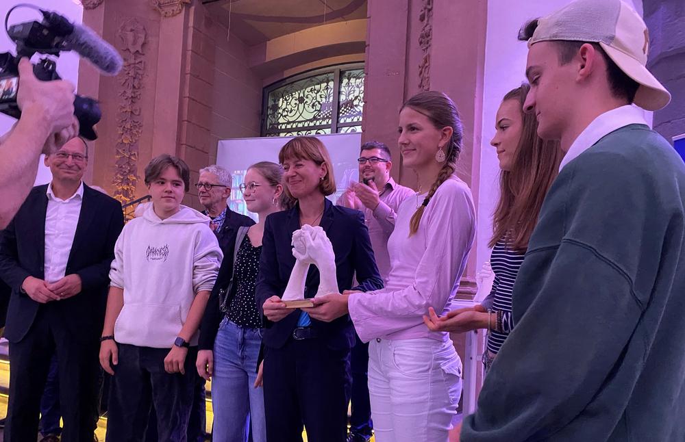 Mit seinen Schüler:innen freut sich Lehrer Martin Krieger über den Abrahamspokal, den Sozialministerin Heike Hoffmann an die Jugendlichen der Klasse 10 übergab. I Foto: Bettina Behler