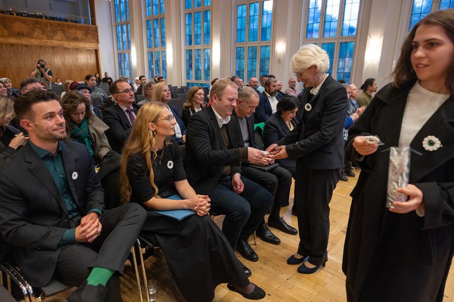 Susanna Faust Kallenberg, Bildmitte, beim Verteilen der weißen Gedenkrosen I Foto: Rolf Oeser