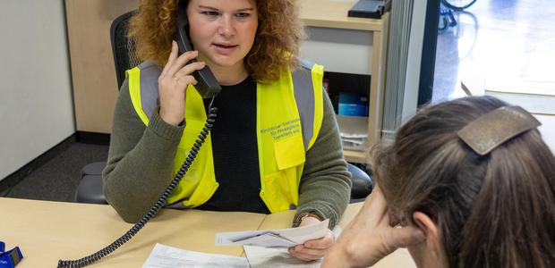 Die hauptamtliche Mitarbeiterin Jana Südhoff telefoniert im Beratungsraum des Kirchlichen Sozialdienstes für eine Ratsuchende.