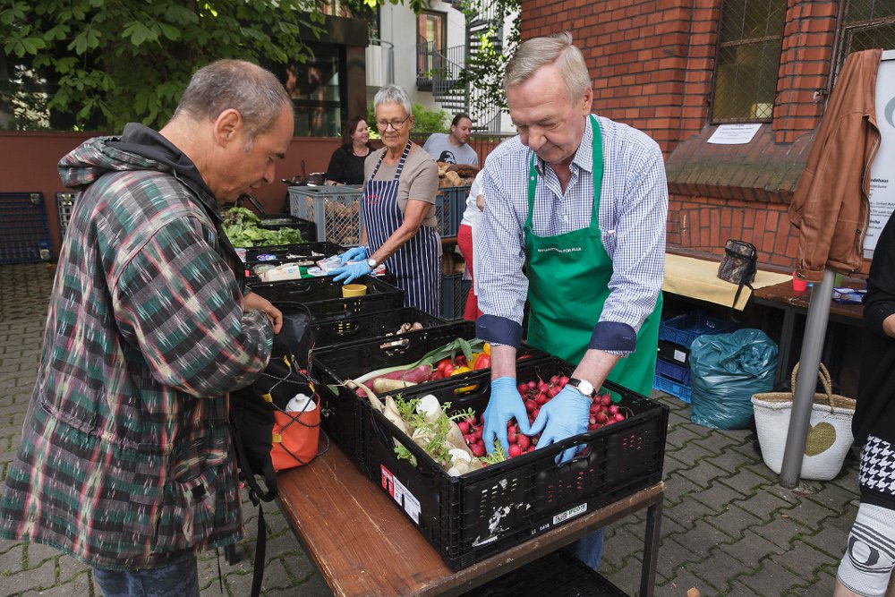 Ehrenamtliche verteilen Lebensmittel im Hof der Christusgemeinde am Merianplatz. Foto: Ilona Surrey