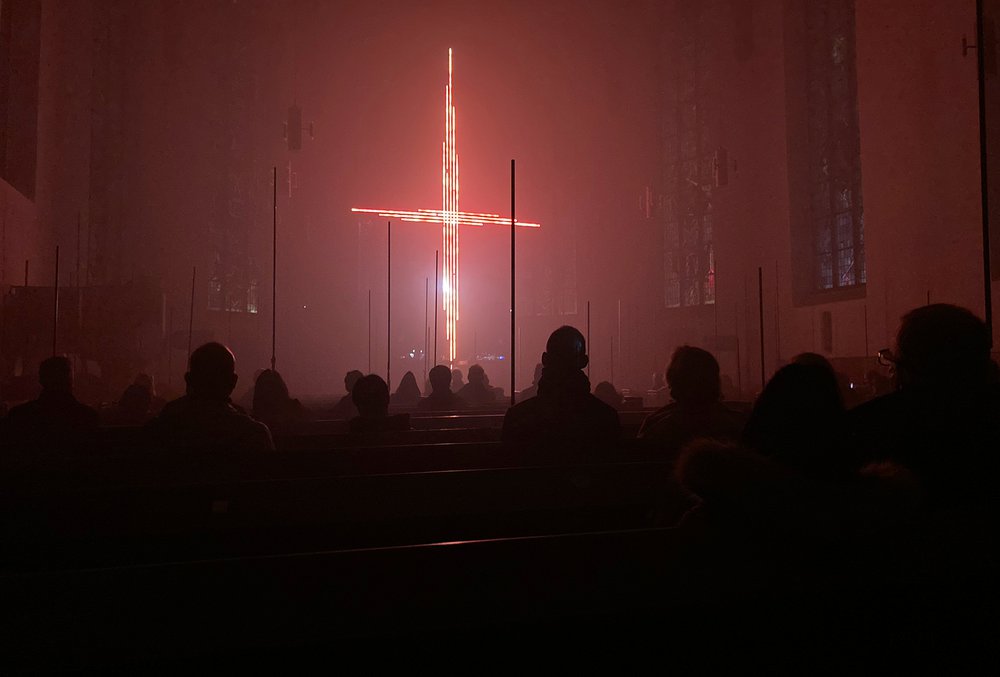 Ein riesiges rotes Lichtkreuz baut sich im Altarraum auf  |  Foto: Felix Volpp