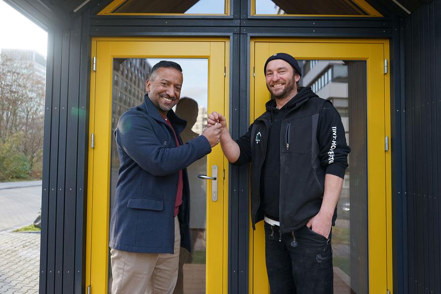 George Kurumthottikal (links) freut sich, von Tiny-House-Bauer Johannes Mager die Schlüssel für die Tiny Church zu bekommen.  |  Foto: Anne Zegelman (Bistum Limburg)