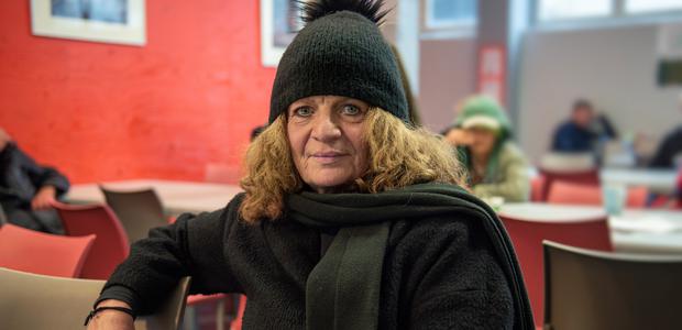 Susann Buße ist das Gesicht der Winterkampagne „Herzschlag der Hoffnung“. Hier sitzt sie an einem Tisch im Tagestreff des Diakoniezentrums WESER5.